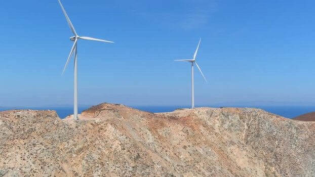 Aerial view of wind turbines on a rocky hill in Islands Greece. Aerial view of wind turbines on a rocky hill in Islands Greece.