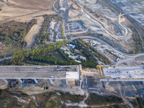 Aerial view of a bridge under construction with concrete pillars heavy machinery and construction vehicles on the deck in Istanbul Istanbul Turkiye.