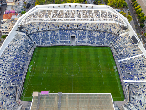 Aerial view of Bloomfield Stadium featuring a vibrant green soccer pitch surrounded by tiered blue and white seating in Tel Aviv Yafo Tel Aviv District Israel. Aerial view of Bloomfield Stadium featuring a vibrant green soccer pitch surrounded by tiered blue and white seating in Tel Aviv Yafo Tel Aviv District Israel.