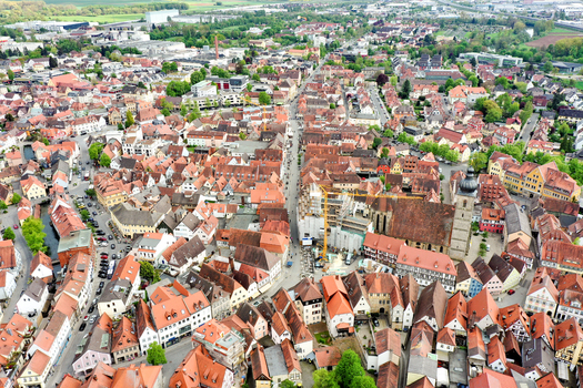 Aerial view of the historic Hauptstrasse and red tiled rooftops of the old town with St. Martin s Church under a clear sky in Forchheim Bayern Germany.