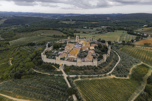 Aerial view of the historic fortified town of Monteriggioni featuring medieval stone walls towers and surrounding vineyards in the Tuscan countryside Monteriggioni Tuscany Italy.