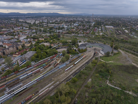 Aerial view of Hungarian Railway Museum with its iconic roundhouse historic locomotives and train tracks surrounded by urban landscape under a cloudy sky in Budapest Hungary. Aerial view of Hungarian Railway Museum with its iconic roundhouse historic locomotives and train tracks surrounded by urban landscape under a cloudy sky in Budapest Hungary.