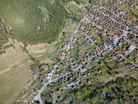 Aerial view of the traditional village houses nestled at the foot of a steep forested mountain slope with green fields in Valaska Dubova Zilina Region Slovakia. Aerial view of the traditional village houses nestled at the foot of a steep forested mountain slope with green fields in Valaska Dubova Zilina Region Slovakia.