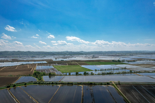 Aerial view of flooded rice fields and the Abbazia di Lucedio surrounded by a grid of water filled paddies and distant hills in Trino Piemonte Italy.