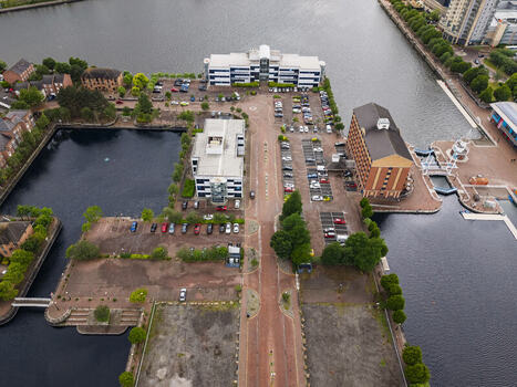 Aerial view of MediaCityUK featuring modern office buildings parking lots and waterfront docks along the Manchester Ship Canal in Salford England United Kingdom. Aerial view of MediaCityUK featuring modern office buildings parking lots and waterfront docks along the Manchester Ship Canal in Salford England United Kingdom.