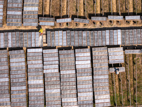 Aerial view of workers drying noodles on racks in a field in Polanharjo Central Java Indonesia.
