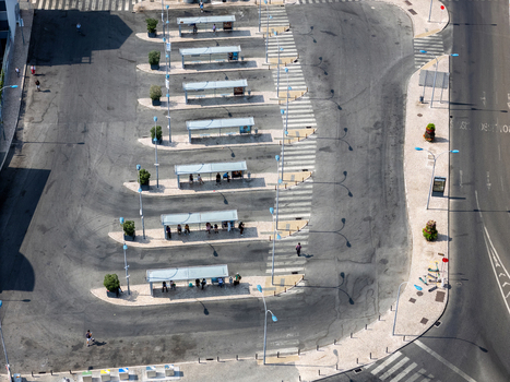 Aerial view of the bus terminal with multiple shelters people waiting and paved lanes in Alges Lisbon Portugal.