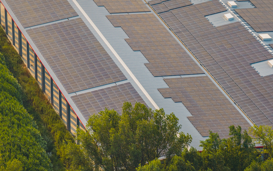 Aerial view of a large rooftop solar photovoltaic installation on an industrial warehouse showcasing sustainable energy infrastructure in Loriol sur Drome Auvergne Rhone Alpes France.