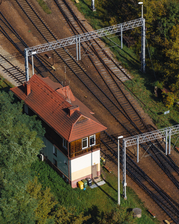 Aerial view of a railway signal box with a red tiled roof located next to multiple railway tracks and overhead power lines in Sosnowiec Wojewodztwo slaskie Poland. Aerial view of a railway signal box with a red tiled roof located next to multiple railway tracks and overhead power lines in Sosnowiec Wojewodztwo slaskie Poland.