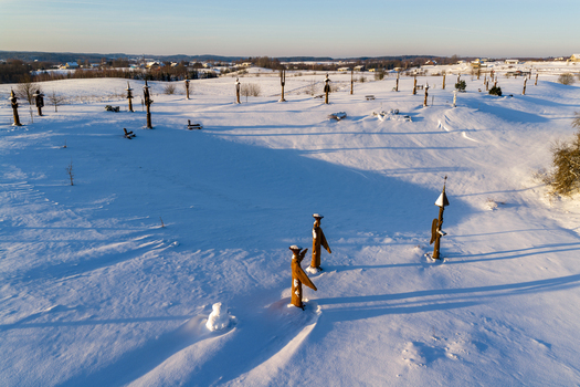 Aerial view of the Hill of Angels featuring wooden sculptures scattered across a snow covered landscape under a clear winter sky in Traku rajonas Vilniaus apskritis Lithuania. Aerial view of the Hill of Angels featuring wooden sculptures scattered across a snow covered landscape under a clear winter sky in Traku rajonas Vilniaus apskritis Lithuania.