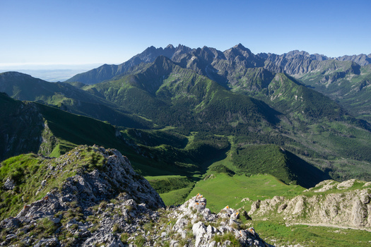 View of the jagged peaks of Zdiarska vidla in Belianske Tatry with lush green valleys and rocky ridges under a clear blue sky in Zdiar Presov Region Slovakia. View of the jagged peaks of Zdiarska vidla in Belianske Tatry with lush green valleys and rocky ridges under a clear blue sky in Zdiar Presov Region Slovakia.