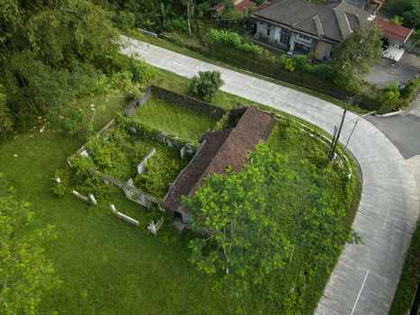 Aerial view of houses damaged by Mount Merapi eruption overgrown with lush vegetation and abandoned stone walls near a paved road in Cangkringan Special Region of Yogyakarta Indonesia. Aerial view of houses damaged by Mount Merapi eruption overgrown with lush vegetation and abandoned stone walls near a paved road in Cangkringan Special Region of Yogyakarta Indonesia.