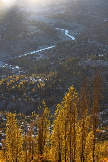 View of the Hunza Valley with golden autumn trees a winding river and village houses in Karimabad GB Pakistan. View of the Hunza Valley with golden autumn trees a winding river and village houses in Karimabad GB Pakistan.