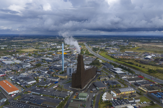 Aerial view of Energitarnet waste to energy plant with steam rising from the chimney and surrounding industrial buildings under heavy clouds Roskilde Denmark. Aerial view of Energitarnet waste to energy plant with steam rising from the chimney and surrounding industrial buildings under heavy clouds Roskilde Denmark.
