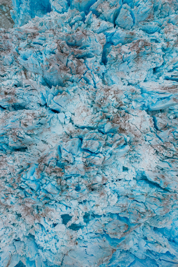 Aerial view of the textured surface of the Mendenhall Glacier featuring deep blue ice jagged crevasses and glacial debris in Juneau Alaska United States. Aerial view of the textured surface of the Mendenhall Glacier featuring deep blue ice jagged crevasses and glacial debris in Juneau Alaska United States.