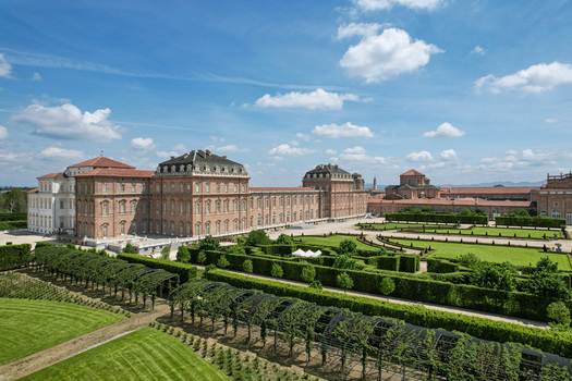 Aerial view of La Venaria Reale palace with its magnificent formal gardens manicured hedges and sprawling lawns under a bright blue sky Venaria Reale Piemonte Italy. Aerial view of La Venaria Reale palace with its magnificent formal gardens manicured hedges and sprawling lawns under a bright blue sky Venaria Reale Piemonte Italy.