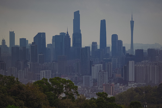 Aerial view of the modern skyline of Guangzhou featuring the iconic Canton Tower and numerous glass skyscrapers under a soft overcast sky in Guangzhou Guangdong Province China. Aerial view of the modern skyline of Guangzhou featuring the iconic Canton Tower and numerous glass skyscrapers under a soft overcast sky in Guangzhou Guangdong Province China.