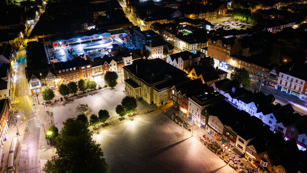 Aerial view of the illuminated Salisbury Market Place at night with historic buildings and street lights in Salisbury Wiltshire United Kingdom. Aerial view of the illuminated Salisbury Market Place at night with historic buildings and street lights in Salisbury Wiltshire United Kingdom.