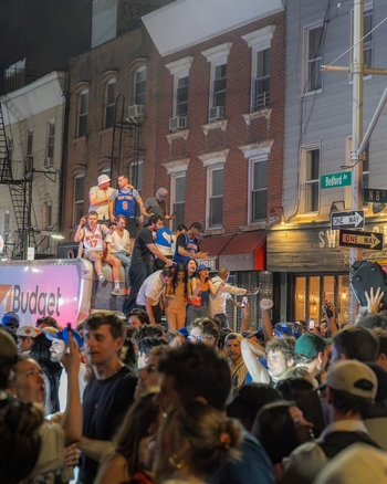 Williamsburg New York USA 14 June 2026 View of Knicks fans celebrating in the street with people wearing basketball jerseys standing on a truck amidst a crowded urban scene at night. Williamsburg New York USA 14 June 2026 View of Knicks fans celebrating in the street with people wearing basketball jerseys standing on a truck amidst a crowded urban scene at night.