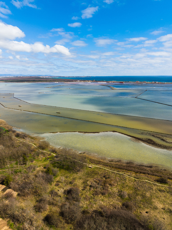 Aerial view of Lake Atanasovsko salt pans with colorful water basins and green vegetation under a blue sky in Burgas Burgas Bulgaria. Aerial view of Lake Atanasovsko salt pans with colorful water basins and green vegetation under a blue sky in Burgas Burgas Bulgaria.