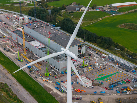 Aerial view of the Green Mountain SVG Undheim data center construction site with a large industrial building cranes and a wind turbine in Undheim Rogaland Norway. Aerial view of the Green Mountain SVG Undheim data center construction site with a large industrial building cranes and a wind turbine in Undheim Rogaland Norway.