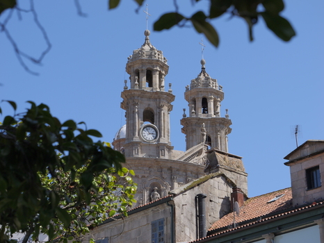 View of the historic Santuario de la Virgen Peregrina with its ornate stone towers and clock face set against a clear blue sky in Pontevedra Pontevedra Spain.