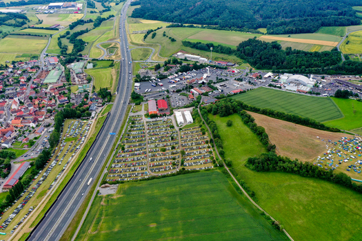 Geiselwind Germany 20 June 2025 Aerial view of Heroes Festival Geiselwind with crowded parking lots the A3 motorway and lush green fields in the Bavarian countryside.