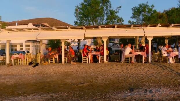 View of people dining at a beachside restaurant in Greece. View of people dining at a beachside restaurant in Greece.