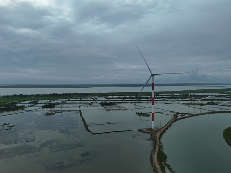 Aerial view of the Khurushkul wind turbine standing in flooded wetlands and shrimp farms under a cloudy sky in Cox s Bazar Chittagong Division Bangladesh. Aerial view of the Khurushkul wind turbine standing in flooded wetlands and shrimp farms under a cloudy sky in Cox s Bazar Chittagong Division Bangladesh.