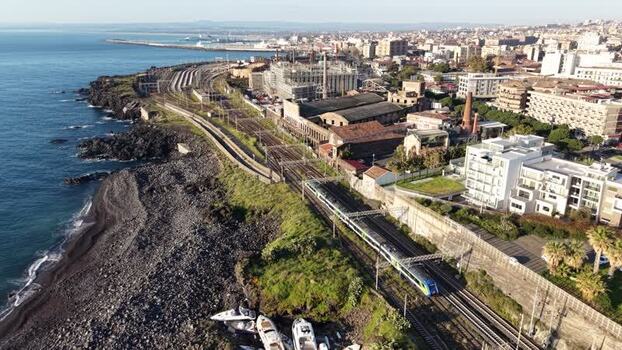 Aerial view of a train traveling along the coast in Catania Italy. Aerial view of a train traveling along the coast in Catania Italy.