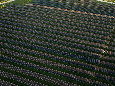 Aerial view of rows of solar panels in a large photovoltaic power plant surrounded by green grass in Augusta Sicily Italy. Aerial view of rows of solar panels in a large photovoltaic power plant surrounded by green grass in Augusta Sicily Italy.