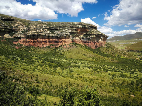 View of Golden Gate Highlands National Park featuring dramatic sandstone cliffs lush green vegetation and rolling hills in Clarens Free State South Africa. View of Golden Gate Highlands National Park featuring dramatic sandstone cliffs lush green vegetation and rolling hills in Clarens Free State South Africa.