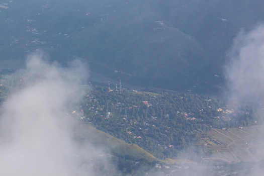 View of a serene landscape with lush green trees houses and three antennas partially veiled by soft ethereal clouds Pir Chanasi Azad Kashmir Pakistan. View of a serene landscape with lush green trees houses and three antennas partially veiled by soft ethereal clouds Pir Chanasi Azad Kashmir Pakistan.