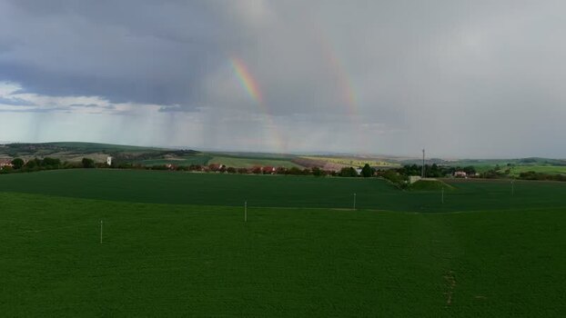 Aerial view of double rainbow over green fields and hills Czechia.