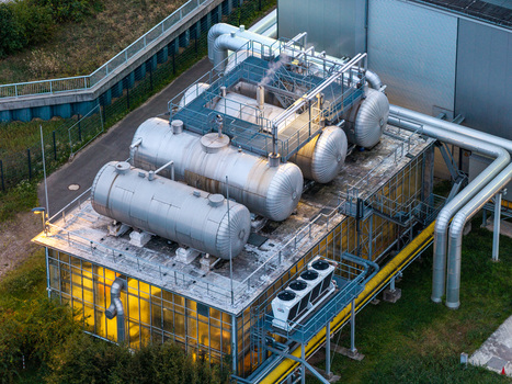 Berlin Germany 07 September 2026 Aerial view of BTB Heizkraftwerk Adlershof featuring large industrial storage tanks complex piping and cooling units atop a glass walled facility.