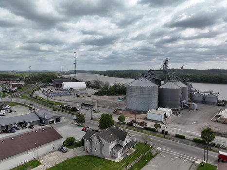 Aerial view of large industrial grain silos and storage facilities along the riverbank under a cloudy sky in Aurora Indiana United States. Aerial view of large industrial grain silos and storage facilities along the riverbank under a cloudy sky in Aurora Indiana United States.