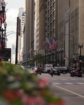 Chicago United States 15 September 2025 View of a busy downtown street with American flags hanging from historic buildings traffic and pedestrians near Adams Street.