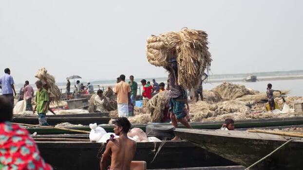 View of workers carrying jute fiber on their heads in Bangladesh.