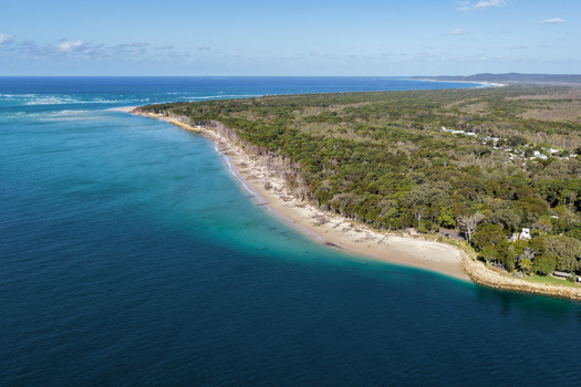 Aerial view of the coastline at Minjerribah North Stradbroke Island showing turquoise waters of Moreton Bay sandy beach and lush forest in Amity Point Queensland Australia. Aerial view of the coastline at Minjerribah North Stradbroke Island showing turquoise waters of Moreton Bay sandy beach and lush forest in Amity Point Queensland Australia.