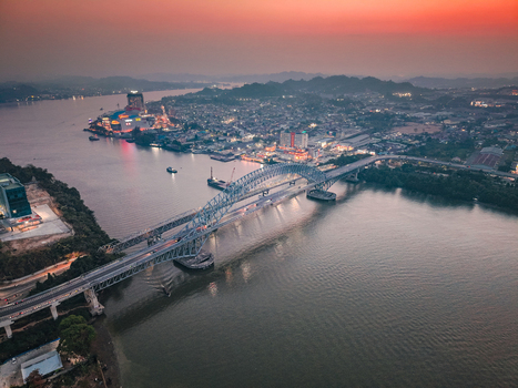 Aerial view of Jembatan Mahakam I spanning the Mahakam River at dusk with city lights illuminating the urban landscape in Kecamatan Samarinda Seberang Kalimantan Timur Indonesia. Aerial view of Jembatan Mahakam I spanning the Mahakam River at dusk with city lights illuminating the urban landscape in Kecamatan Samarinda Seberang Kalimantan Timur Indonesia.
