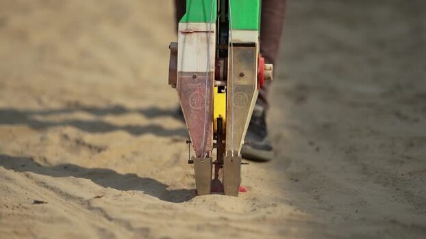 View of a manual seed planter tool being used in sandy soil Nepal. View of a manual seed planter tool being used in sandy soil Nepal.