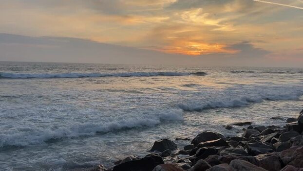 View of waves crashing on a rocky shore at sunset United States. View of waves crashing on a rocky shore at sunset United States.