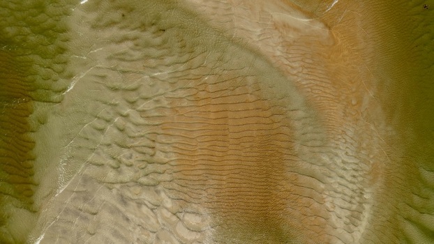 Aerial view of the intricate sandbars and tidal patterns at Matanzas Inlet showcasing ripples in the shallow water and golden sand textures St. Johns County Florida United States. Aerial view of the intricate sandbars and tidal patterns at Matanzas Inlet showcasing ripples in the shallow water and golden sand textures St. Johns County Florida United States.