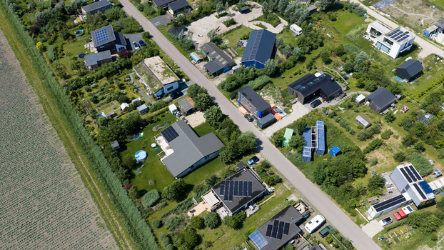 Aerial view of Ecodorp Bolderburen featuring modern sustainable houses with solar panels lush green gardens and surrounding agricultural fields in Almere Flevoland Netherlands. Aerial view of Ecodorp Bolderburen featuring modern sustainable houses with solar panels lush green gardens and surrounding agricultural fields in Almere Flevoland Netherlands.
