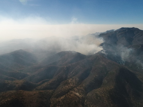 Aerial view of Sierra de San Miguelito with smoke rising from a wildfire over the rugged mountain range in San Luis Potosi San Luis Potosi Mexico.