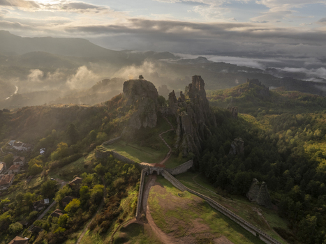 Aerial view of Belogradchik Fortress perched on dramatic rock formations surrounded by lush forests and rolling hills in Belogradchik Vidin Bulgaria. Aerial view of Belogradchik Fortress perched on dramatic rock formations surrounded by lush forests and rolling hills in Belogradchik Vidin Bulgaria.