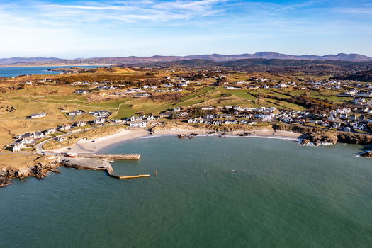 Aerial view of the coastal village of Portnablagh with its sandy beach stone pier and surrounding green hills in Portnablagh County Donegal Ireland. Aerial view of the coastal village of Portnablagh with its sandy beach stone pier and surrounding green hills in Portnablagh County Donegal Ireland.