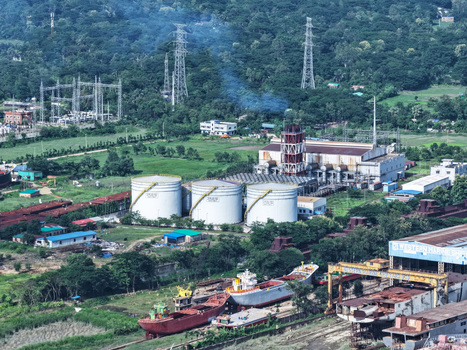 Aerial view of the Karnaphuli River industrial area with large storage tanks a shipyard and power infrastructure in Chattogram Chattogram Division Bangladesh.