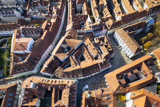 Aerial view of terracotta rooftops create a warm mosaic amidst the old town s narrow streets a tapestry of history unfolding from above Graz Styria Austria.