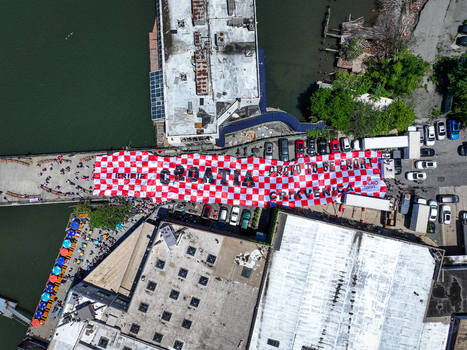 Long Island City United States 13 June 2026 Aerial view of a large red and white checkered Croatia banner held by fans on a pier near the water.